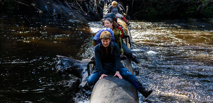 TLC staff Sally Bryant, Denna Kingdom and Marilyn Pauley crossing the Gordon River, illustrating just how hard you have to work to reach Gordonvale - by Grant Dixon